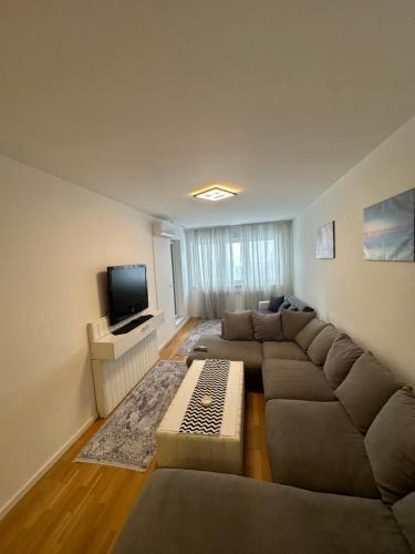 a living room with a couch and a tv at Elma Meandar otoka in Sarajevo