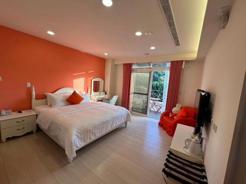 a bedroom with a bed with an orange wall at Bei Ao Bi Shan Jyu in Dongyin
