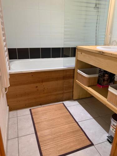 une salle de bain avec une baignoire et un lavabo dans l'établissement Les fermes de saint gervais, à Saint-Gervais-les-Bains