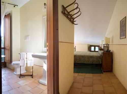 a bathroom with a sink and a toilet and a bed at Torre Camigliati Dimora Storica in Camigliatello Silano