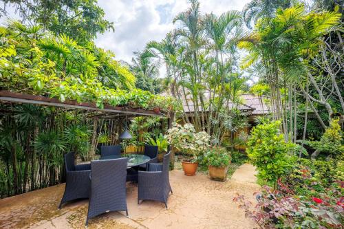 a patio with a table and chairs and plants at 11 Rooms in Chiang Dao