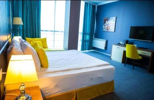 a hotel room with a large bed and a television at Square Boutique Hotel in Baku