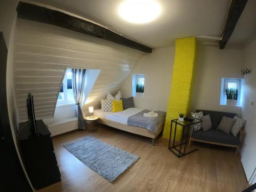 a bedroom with a bed and a couch in a room at Stilvolle Altbauwohnung, Apartment Feder & leicht in Höhr-Grenzhausen