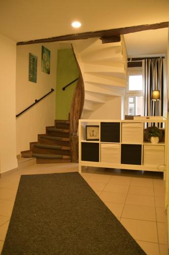 a living room with a staircase and a carpet at Stilvolle Altbauwohnung, Apartment Feder & leicht in Höhr-Grenzhausen
