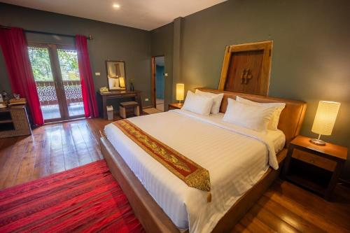 a bedroom with a large bed and a large window at 11 Rooms in Chiang Dao