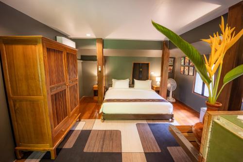 a bedroom with a bed and a plant at 11 Rooms in Chiang Dao