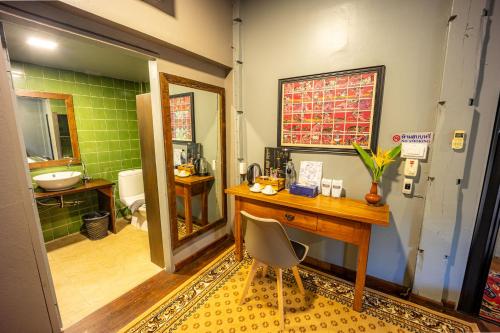 a bathroom with a desk and a sink and a toilet at 11 Rooms in Chiang Dao