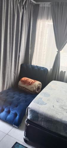 a bedroom with a blue bed and a window at Sunset Guest House in Roodepoort