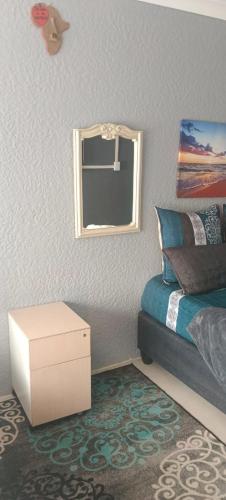 a bedroom with a bed and a mirror on the wall at Sunset Guest House in Roodepoort