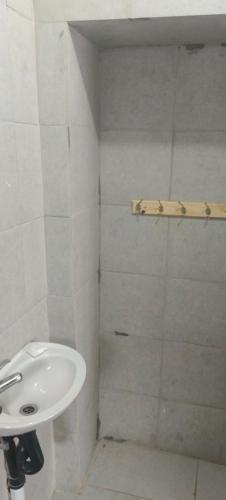 a white bathroom with a sink and a shower at Sunset Guest House in Roodepoort