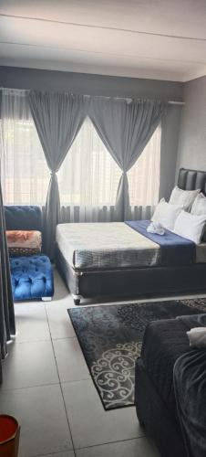 a bedroom with two beds and a window at Sunset Guest House in Roodepoort