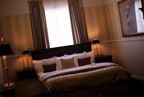 a bedroom with a bed with pillows and a window at Redearth Boutique Hotel in Mount Isa