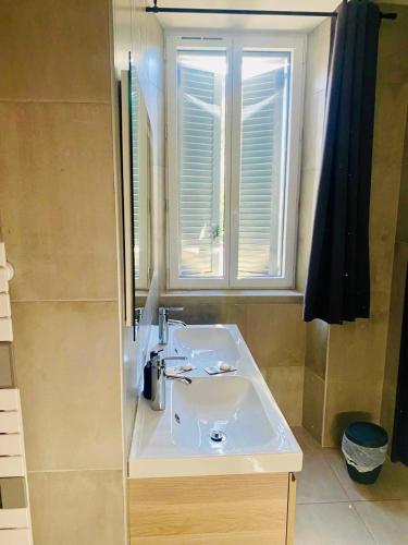 a bathroom with a sink and a window at LE RELAIS DES COLS in Cozzano