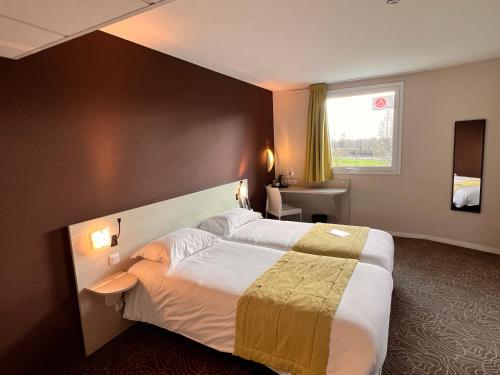 Ένα ή περισσότερα κρεβάτια σε δωμάτιο στο Brit Hotel Saint-Méen-le-Grand en Brocéliande