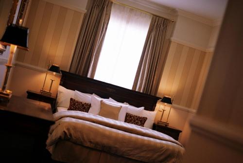 a bedroom with a bed with a window and two lamps at Redearth Boutique Hotel in Mount Isa