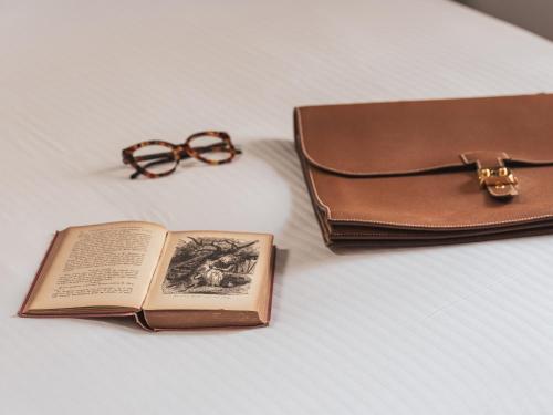 a book next to a purse and a wallet at Hotel Madeleine De Senlis in Paris