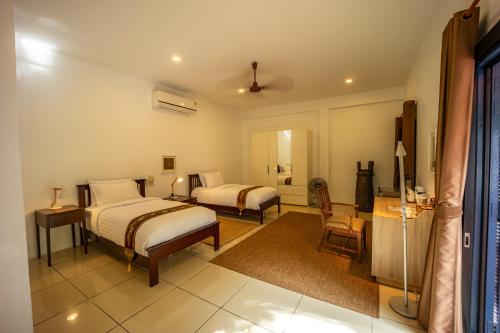 a hotel room with two beds and a chair at 11 Rooms in Chiang Dao