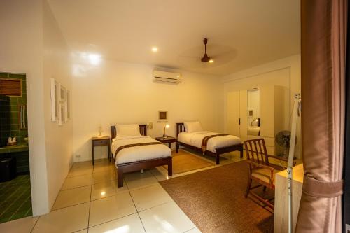 a bedroom with two beds and a couch and a table at 11 Rooms in Chiang Dao