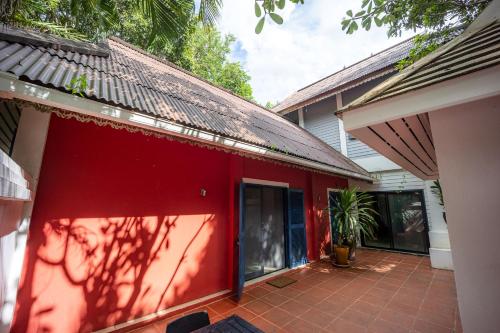 a red house with a red wall and a patio at 11 Rooms in Chiang Dao
