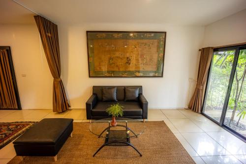 a living room with a leather couch and a table at 11 Rooms in Chiang Dao