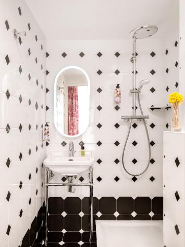 a bathroom with a sink and a mirror at Hotel Madeleine De Senlis in Paris