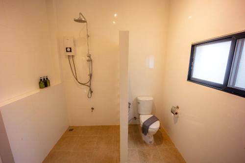 a bathroom with a toilet and a window at 11 Rooms in Chiang Dao
