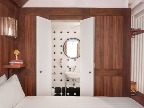 a bedroom with a bed and a mirror and a sink at Hotel Madeleine De Senlis in Paris
