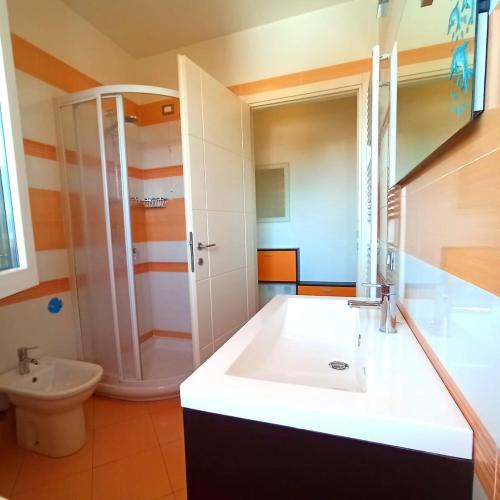 a bathroom with a white sink and a shower at AlMa Apartament in Lucca