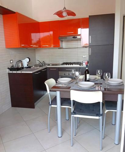a kitchen with red cabinets and a table and chairs at AlMa Apartament in Lucca