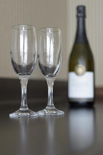 two empty wine glasses next to a bottle of wine at Redearth Boutique Hotel in Mount Isa