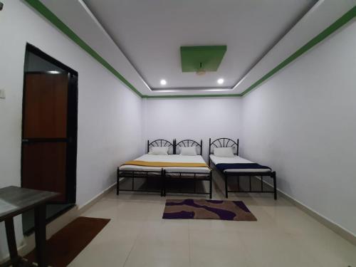 a room with two beds in a room at Hotel Queen Queen Sea in Calangute