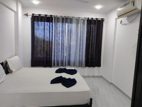 a bedroom with a bed with two robes on it at Hotel Queen Queen Sea in Calangute