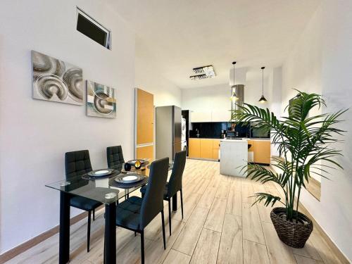 a dining room and kitchen with a table and a plant at Encanto Mediterráneo en Alicante in Alicante