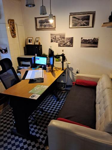 an office with a desk with a computer and a couch at Penzion Betlém in Janske Lazne