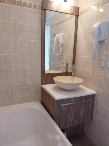 une salle de bain avec un lavabo, un miroir et une baignoire dans l'établissement Très belle villa 2 avec piscine, à Callian