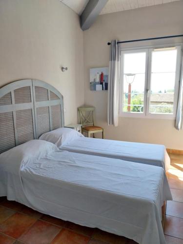 - un lit blanc dans une chambre avec fenêtre dans l'établissement Très belle villa 2 avec piscine, à Callian