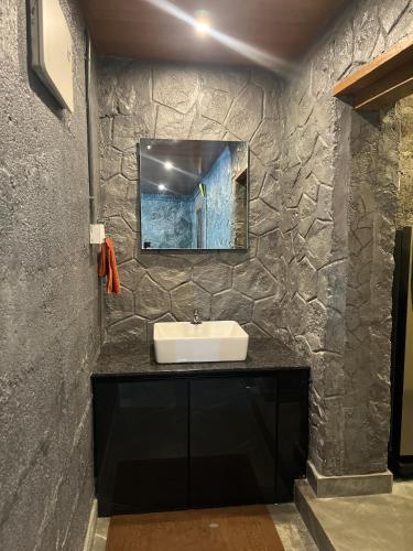 a bathroom with a sink and a mirror on a wall at Elora Resort Wayanad in Kalpetta