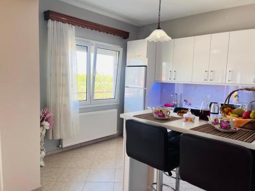 a kitchen with a island with a bowl of fruit on it at Nefeli luxury apartment in Aronás