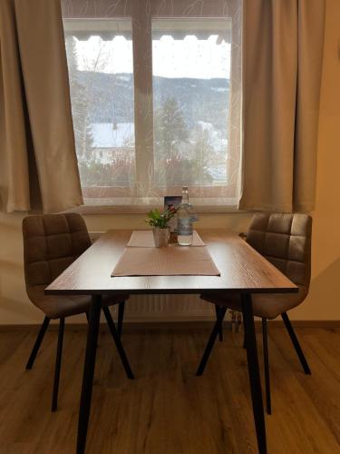 a table and two chairs in front of a window at Ferienhof Alte Post, Apartments in Weissbriach
