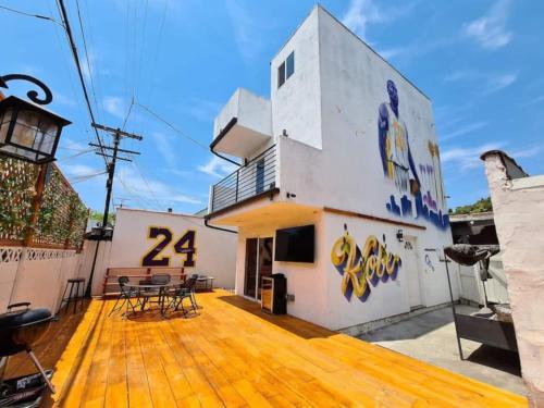 a house with a large wooden deck with a building with the number at 3 bedroom with Hot Tub and Video game console 10 minutes from Rodeo Drive Beverly Hills in Los Angeles