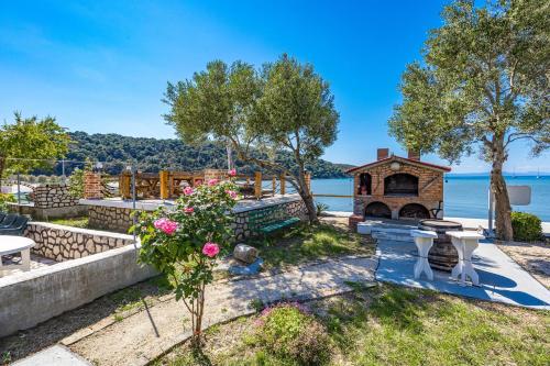 a backyard with a pizza oven next to the water at Apartments Emily in Kampor
