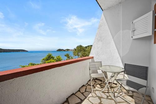 a balcony with chairs and a view of the water at Apartments Emily in Kampor