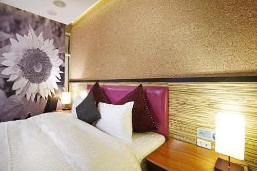 a bedroom with a bed with a flower on the wall at 薇風情汽車旅館 - 台南館 in Liujia