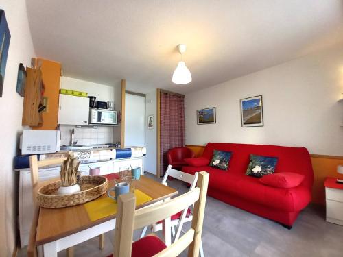 un salon avec un canapé rouge et une table dans l'établissement Saint Palais sur Mer - STUDIO - résidence LES SABLES D'OR - CENTRE VILLE, à Saint-Palais-sur-Mer