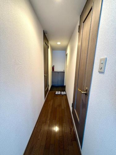 an empty hallway with an open door and wooden floors at 8-1閑静なエリア豊平川目の前でゆったりと静かな旅行可能 in Sapporo