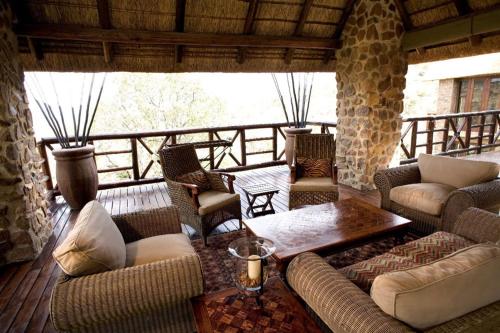 a living room with couches and a table on a porch at Schrikkloof Private Nature Reserve, home of The Lions Foundation in Bela-Bela