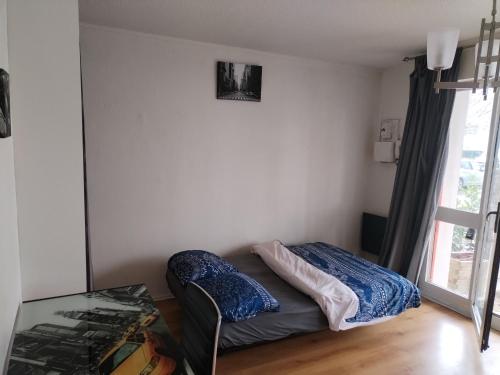 un lit dans une chambre avec une fenêtre dans l'établissement Votre studio à Pessac, à Pessac