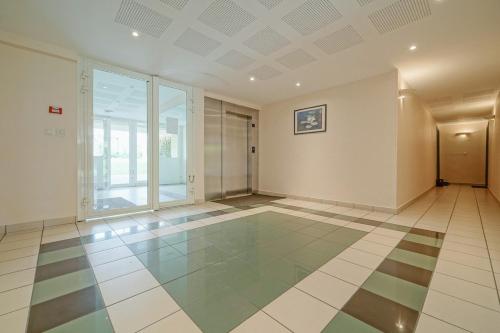 Cette chambre vide dispose d'une grande fenêtre et de carrelage. dans l'établissement Appartement spacieux avec balcon - proche Paris, à Saint-Denis