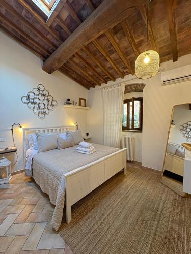 a bedroom with a large bed with a wooden ceiling at Bouganville in Rosignano Marittimo