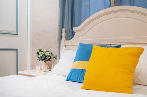 a bed with a yellow and blue pillow on it at Misty Nest High Altitude River View B&B Hongyadong Branch in Chongqing